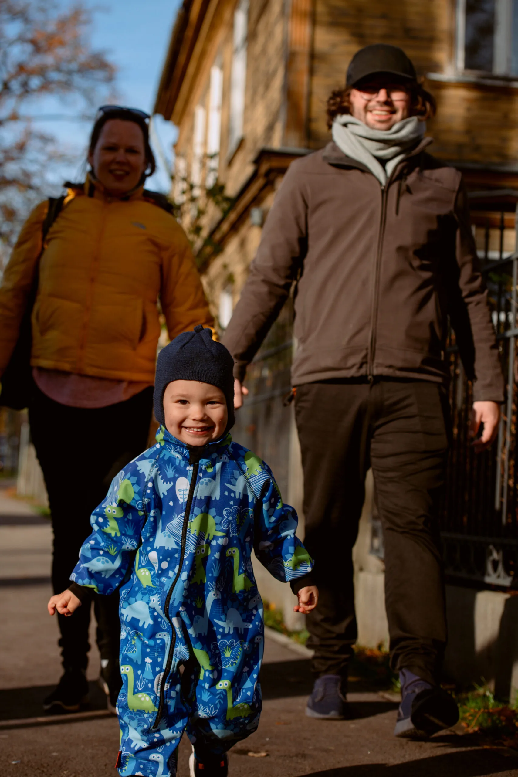 Familie på tre går sammen utenfor sitt nye hjem